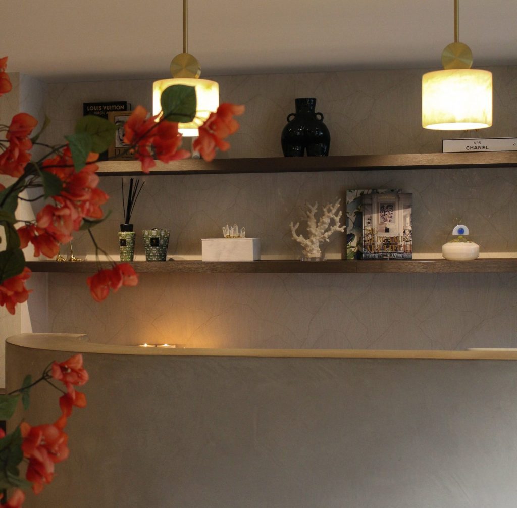 Interieur van House of Bratz Rotterdam met wandplanken, messing hanglampen en oranje bloemen