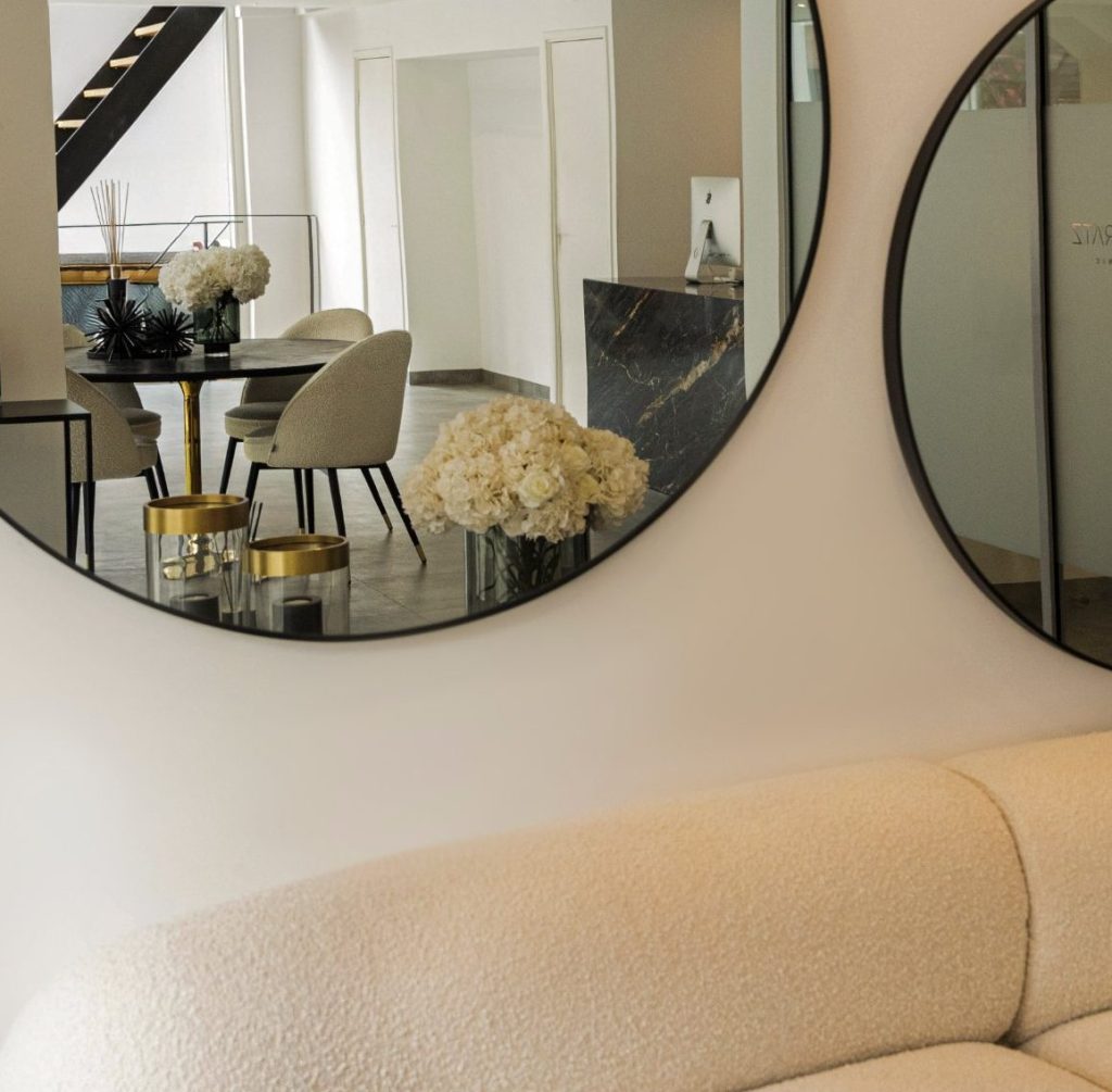 Interieur van House of Bratz Amsterdam met ronde spiegels en een crèmekleurige bank