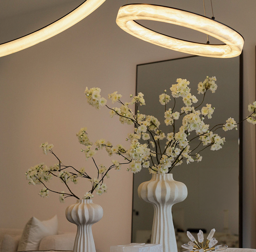 Interieur van House of Bratz Antwerpen met ringlampen en witte vazen met bloesem